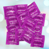 A cluster of LifeStyles "Snugger Fit" condoms in purple packaging lies scattered across a light, soft-focus background. The white text on the packaging prominently displays the LifeStyles brand and highlights their skin-tight fit, designed for a smaller size option.